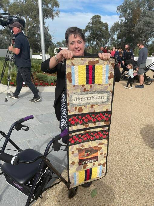 Handiwork: Lisa Ride shows off the patched quilt she made with symbols from the Afghanistan war.