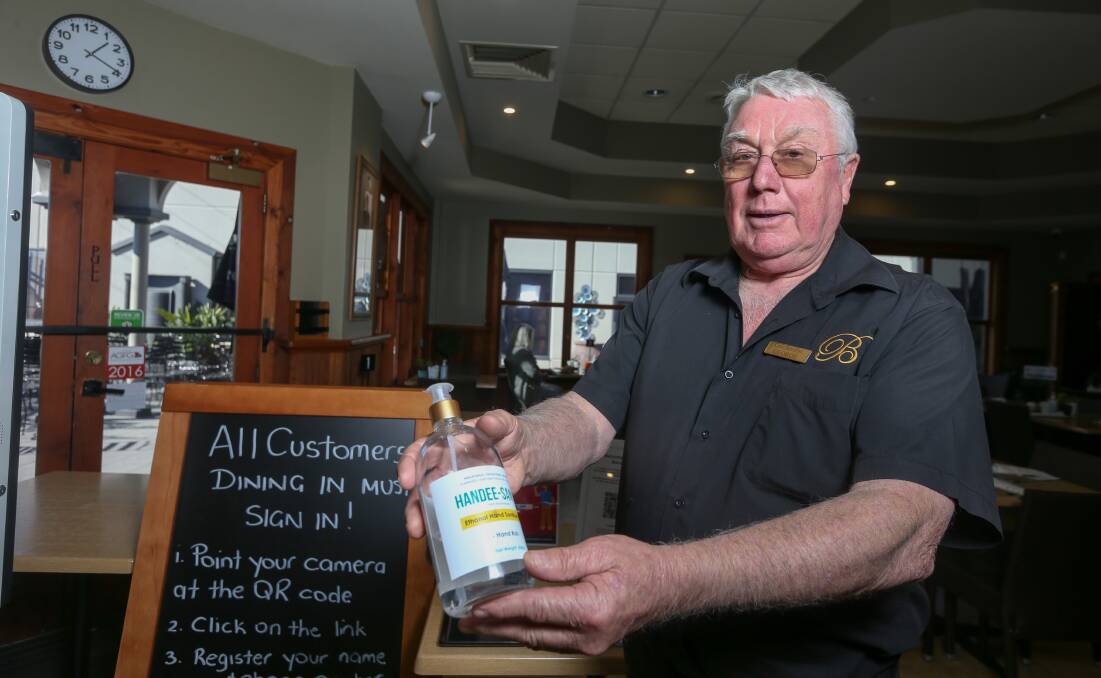 Measures on hand: Cafe Borellas owner George Benyon with liquid soap that is at the entrance to his eatery along with identity checks in electronic and written form. Picture: TARA TREWHELLA
