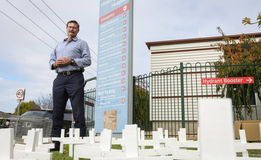 Bill Tilley with his array of white crosses which dotted the nature strip outside Wodonga hospital on Wednesday. Picture by James Wiltshire