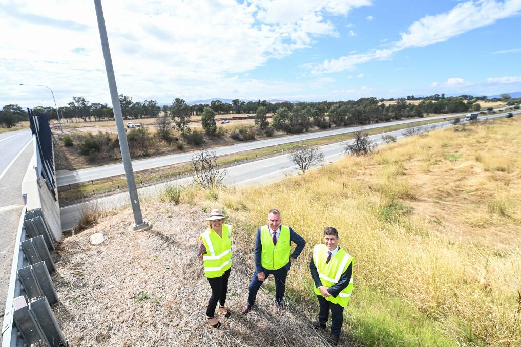 Blending in: Sussan Ley, Kevin Mack and Justin Clancy donned yellow safety tops that almost matched the grass on the slope near the Davey Road interchange. It will soon be removed as part of the installation of new ramps at the site. Picture: MARK JESSER 
