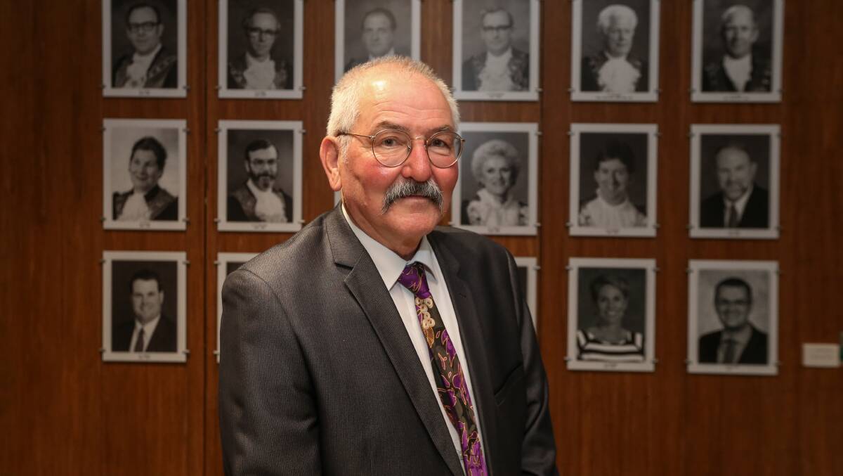 Wodonga mayor Ron Mildren in front of pictures of his predecessors in the council chamber where he on Monday night made a plea for the Victorian government to not ignore the city's looming health summit.