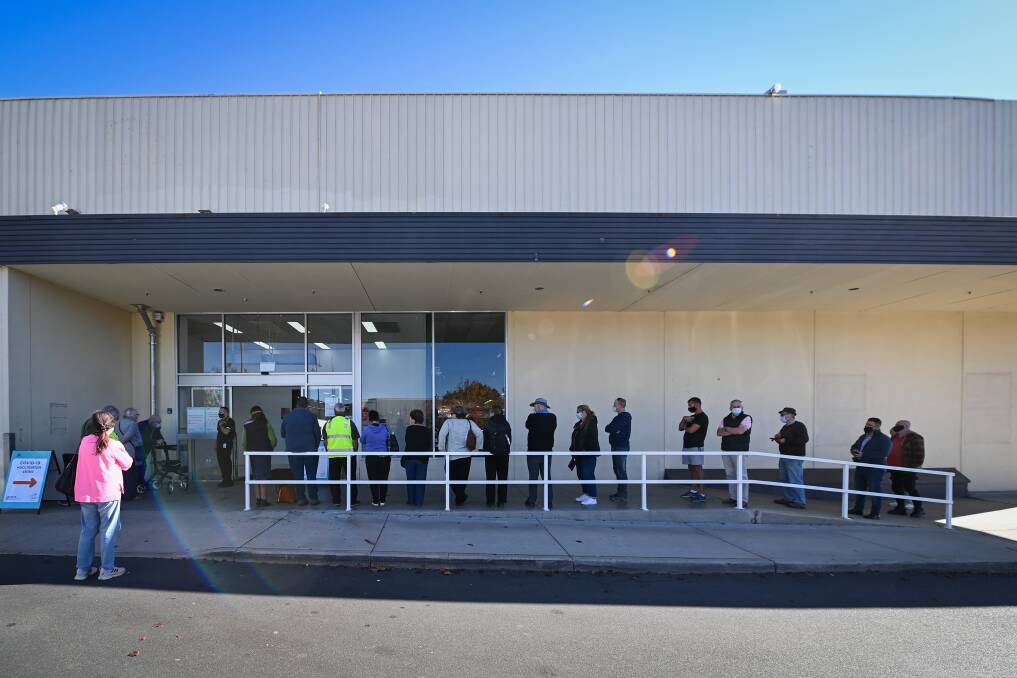 Queueing up: Vaccine seekers line up for their injections at the former Coles supermarket in Wodonga yesterday. Picture: MARK JESSER
