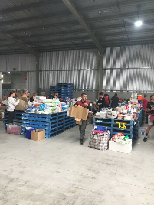 Overwhelmed: Volunteers sought through the mass of goods donated at Merriwa Industries in Wodonga to assist fire victims. 