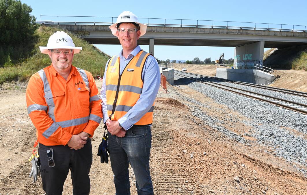 The ARTC's Ed Walker and McConnell Dowell project manager Tom Foley can afford to smile after the completion of track lowering works at Barnawartha North. Picture by Mark Jesser