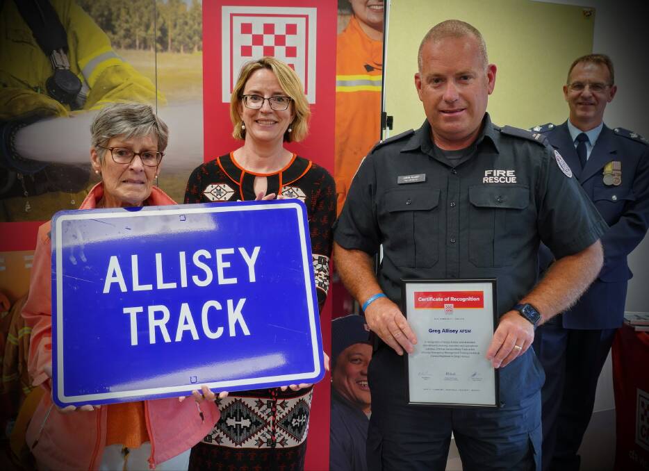Full of pride: Robyn and Jason Allisey with the replica road sign and certificate of recognition marking their husband and father Greg Allisey. CFA chief executive Natalie McDonald is between them.