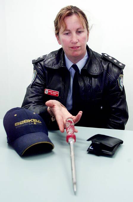 At work: Detective Senior Constable Marg Saunders pictured in 2001 with items related to break-ins around Albury.