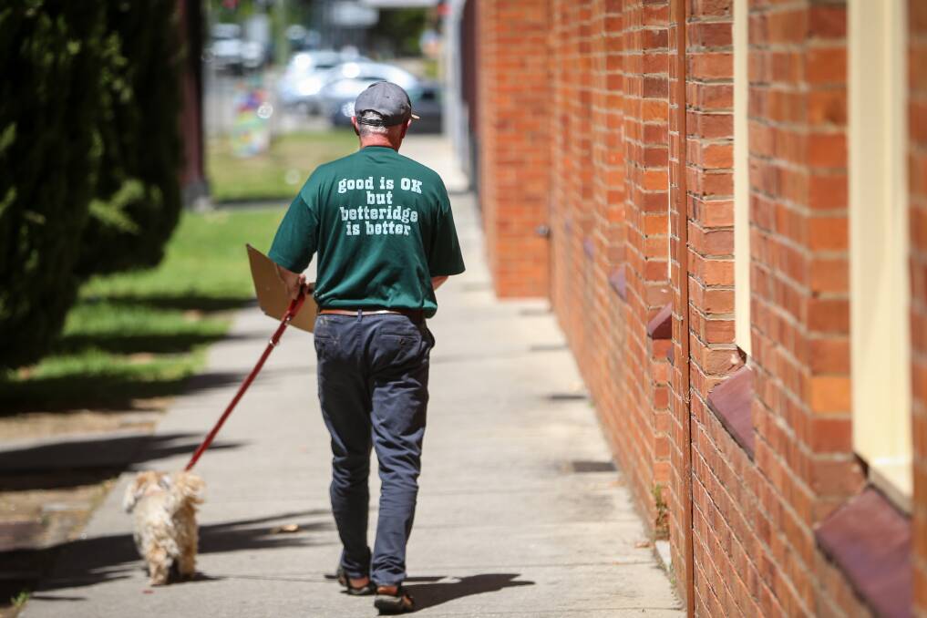 Taken down: Candidate Daryl Betteridge walks off with dog Winston and election posters he was told to remove. Picture: JAMES WILTSHIRE