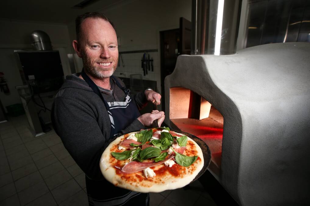 Topping up: Steve Hams with his new concrete wood-fired oven. He and wife Jennifer Waugh have owned Hollywoods for the past two years. Picture: JAMES WILTSHIRE