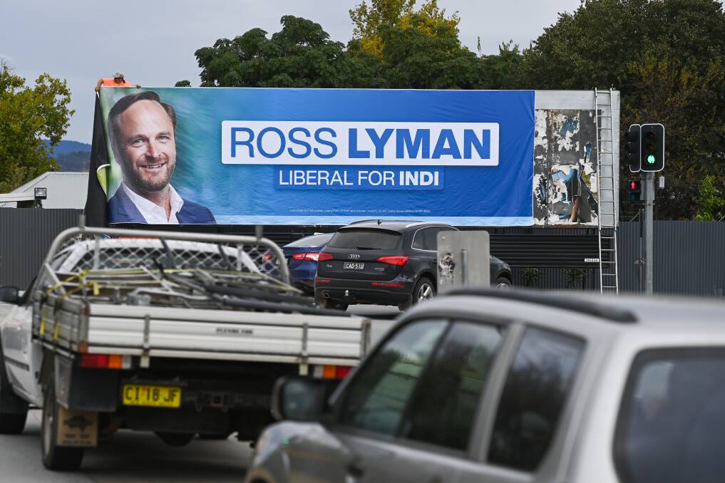 North facing: Ross Lyman's Albury advertisement being put on a billboard at the city's former rollover corner last week. Picture: MARK JESSER