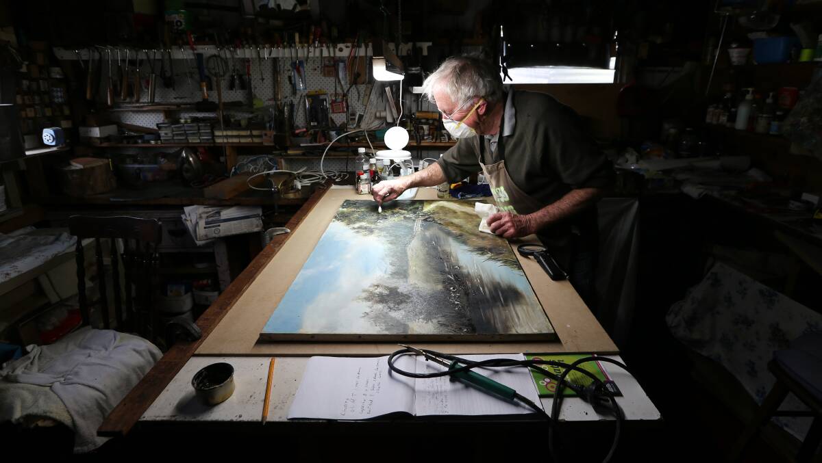 AT work: Ken Ashley restores a landscape by D.Hamilton, an artist believed to be an Englishman working in Australia. Picture: KYLIE ESLER