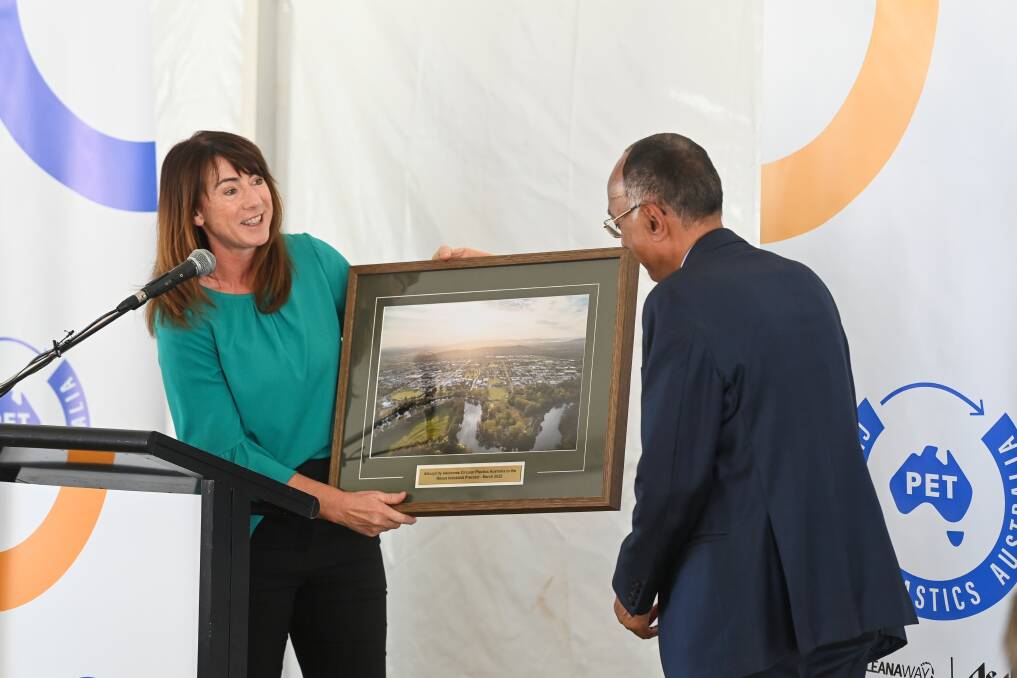 Memento: Albury mayor Kylie King presents a photograph of Albury, looking back from the Murray River, to Pact boss Sanjay Dayal at the official opening of the new plastics recycling factory at Nexus on Friday. Picture: MARK JESSER