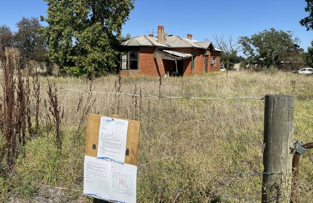 The overgrown front yard of the Corowa property with notices from Federation Council on the fence line ordering it be cleaned up.