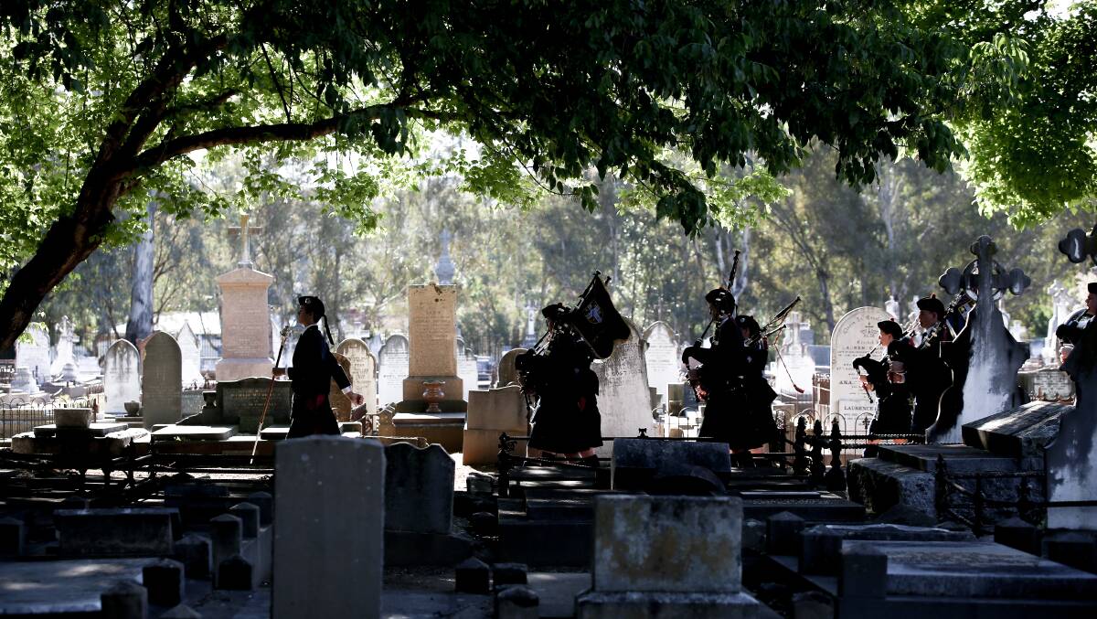 In the shadows: The Scots School Albury band leaves the cemetery after a tiring performance in the November heat. Picture: JAMES WILTSHIRE