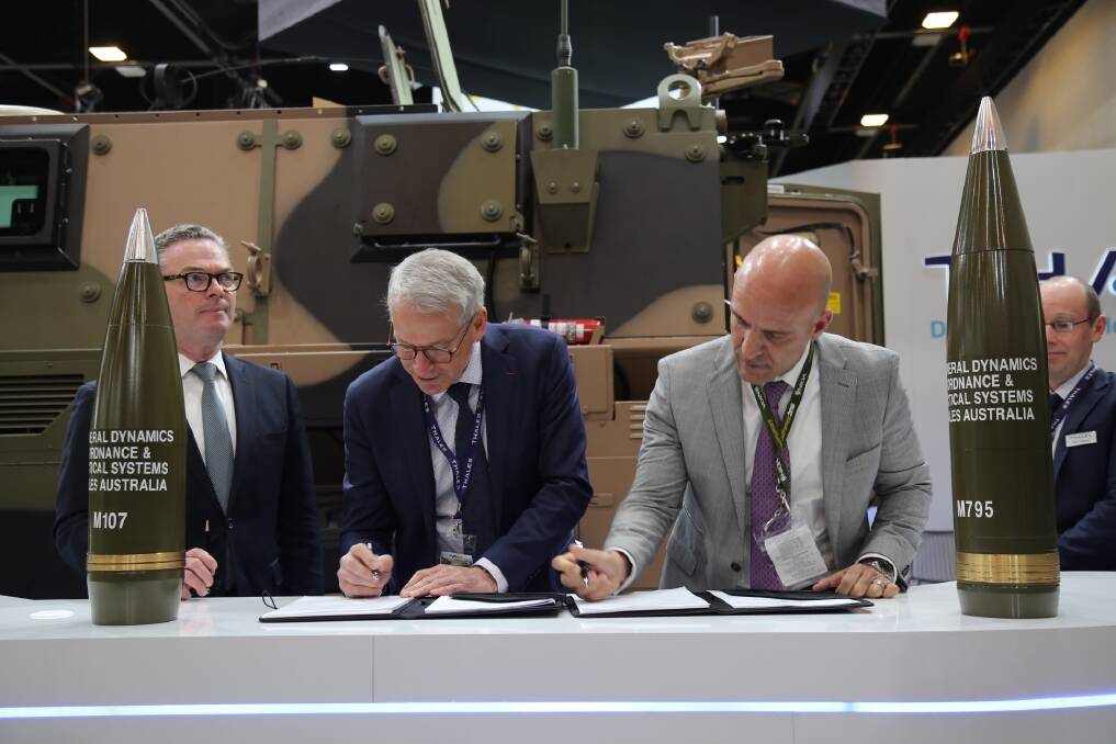 Done deal: Defence Minister Christopher Pyne looks away as Thales chief executive Chris Jenkins and GD-OTS president Firat Gezen sign up in Adelaide yesterday.