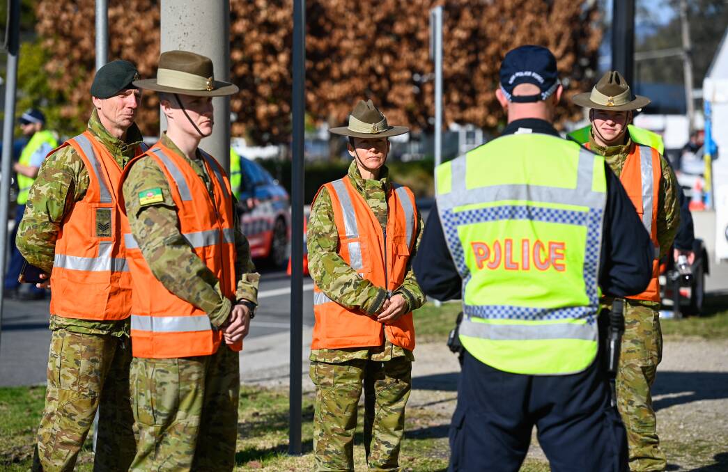 Part of a big group: Soldiers join police at the Albury checkpoint for motorists entering NSW. There are now 500 assisting police along the state's frontier. Picture: MARK JESSER