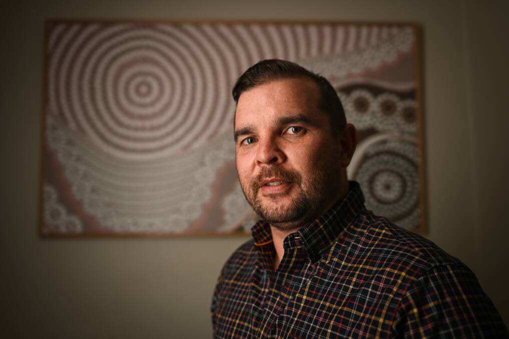 Very welcome: Tyrell Ingram has expressed his appreciation for Albury Council's draft reconciliation action plan. He is pictured in front of painting done by his cousin Samara Plunkett, of Wagga. Picture: MARK JESSER