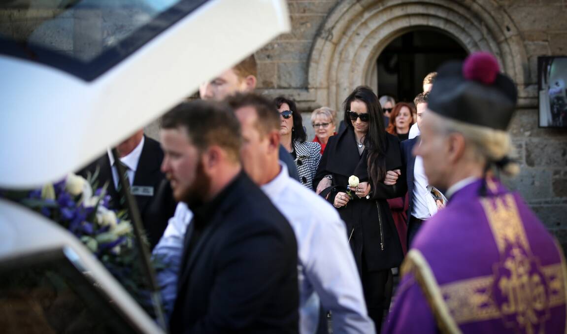 Very special man: Georgia Webb holds a flower as she leaves the church before placing rosemary on the coffin of her boyfriend Ben Pascall.