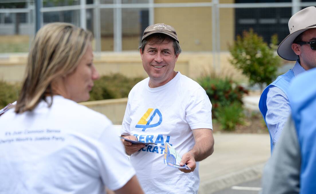 On the hustings: Tim Quilty hands out his hastily printed off how-to-vote brochures at Wodonga's Victory Lutheran School polling booth on Saturday. Picture: MARK JESSER