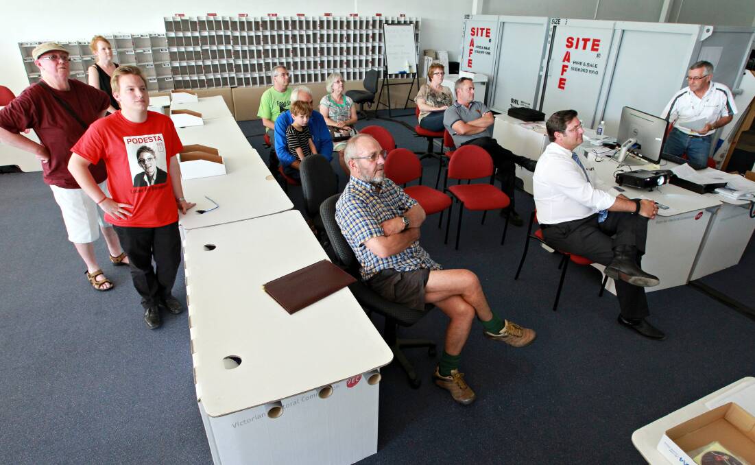 Flashback: Eric Kerr, in red T-shirt with then Labor candidate Jennifer Podesta's image, watches the ballot draw for the 2014 Benambra election. Liberal incumbent Bill Tilley is at the right with white shirt and tie.