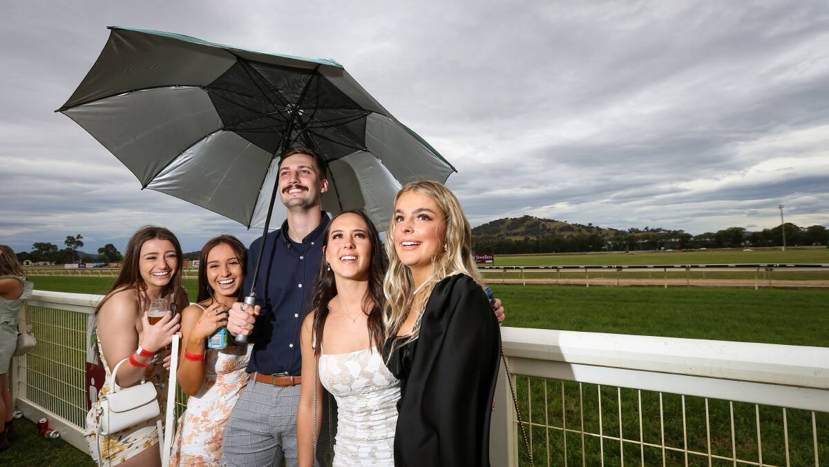 Stephanie Davey, Caitlin Cullen, Max Lewis, Cherie Travassaros and Chiara Hocking were among many race-goers guarding against the rain at Wodonga's races. Picture: JAMES WILTSHIRE
