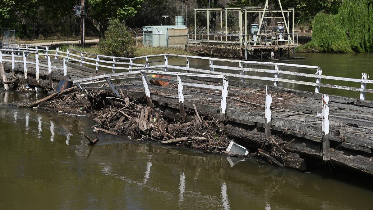 Wooden railings have been left to rot away and the deck is slumping at Wodonga's old stock bridge as flotsam and jetsam is stuck between the water line and side. Picture by Mark Jesser