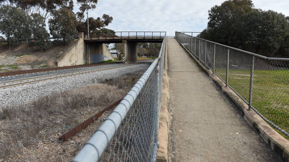 Up for demolition: The existing bridge traversing the railway line near the siege site which is earmarked for removal because it does not allow for double-stacked trains to pass underneath.