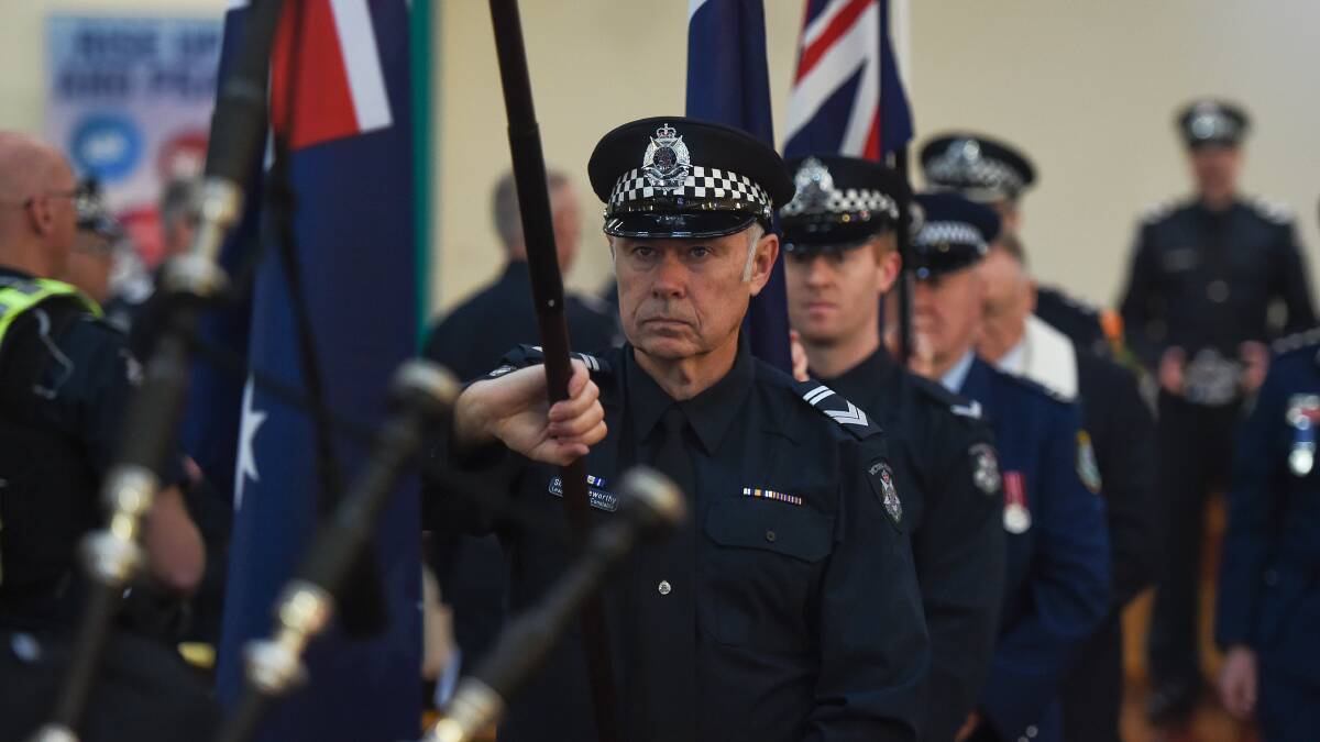 Vanguard: Leading Senior Constable Shane Leeworthy leads flag bearers out of the church at the end of yesterday's police memorial service.