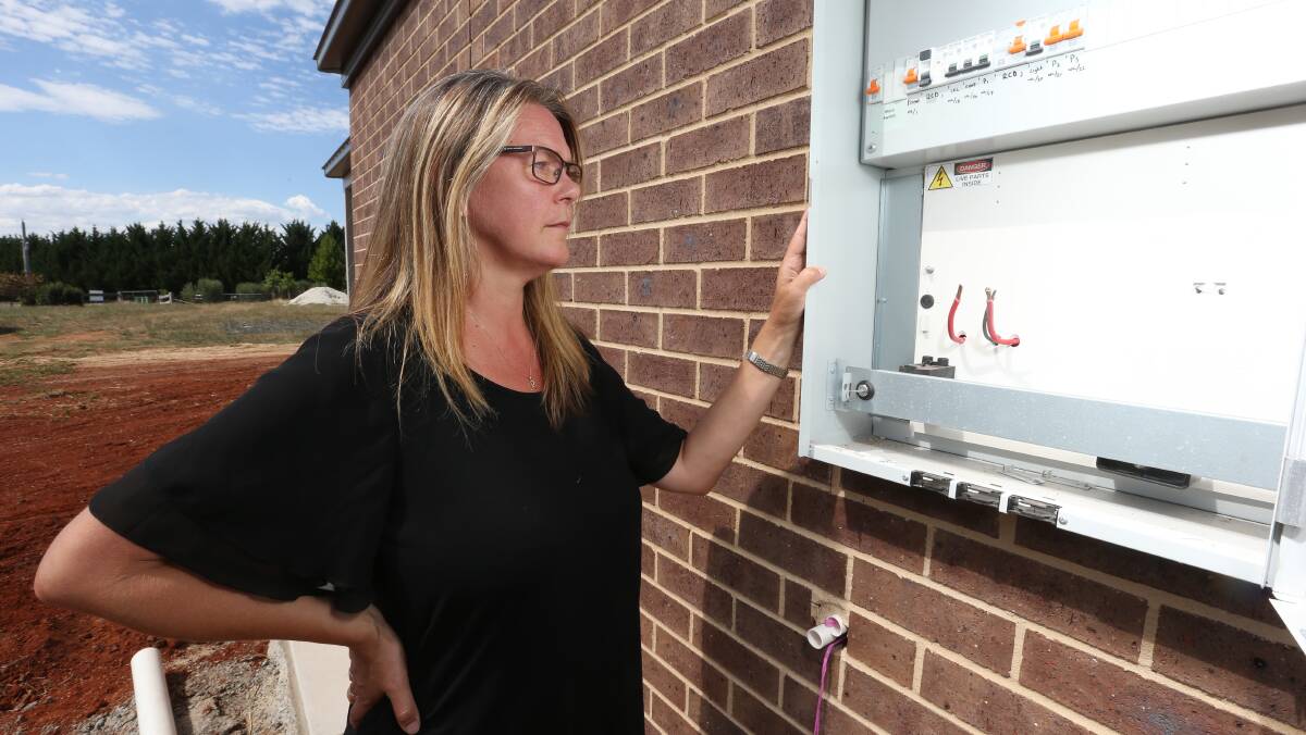 Nothing to see: New home owner Robyn King at her property's switch box. Her situation was raised with Energy Minister in question time yesterday.