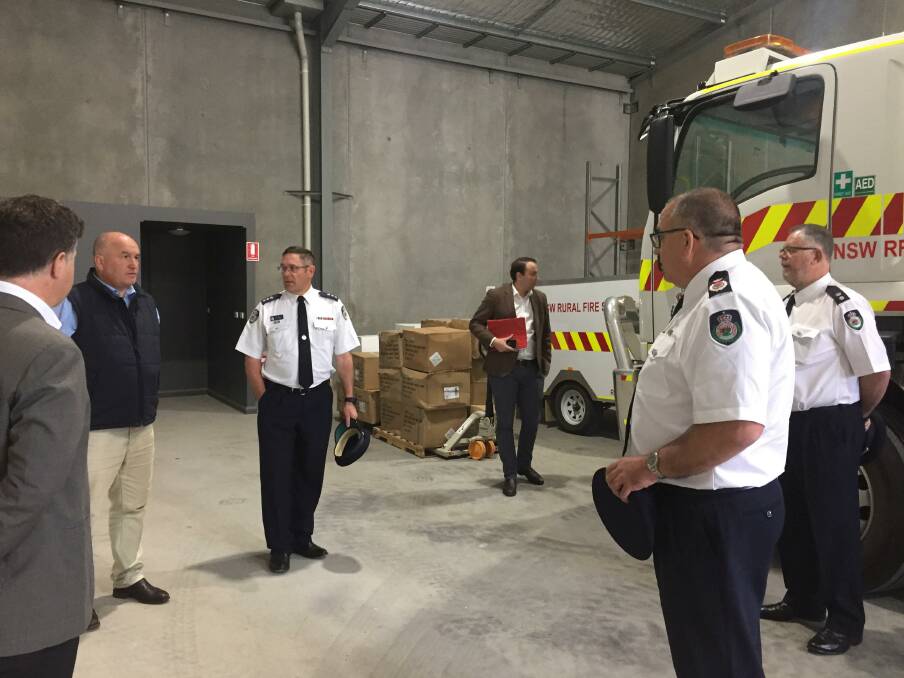 Getting a briefing: NSW Emergency Services Minister David Elliott listens to Rural Fire Service chiefs inside the vehicle parking area of the new regional command premises in Albury.