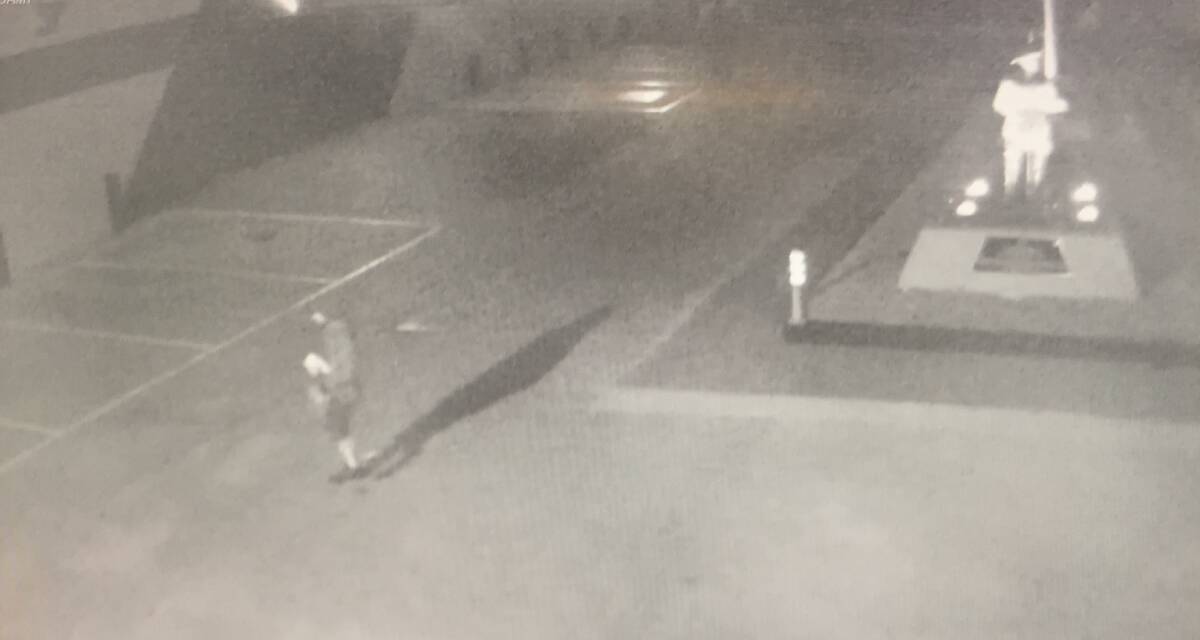 Mystery man: Security camera footage from Peard's showing a trespasser after he has stolen the flag from the pole (at the right) and is heading towards the cafe entrance at the East Albury business.