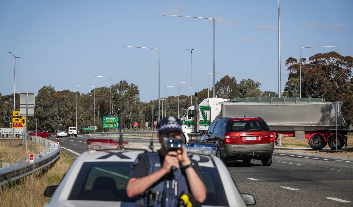 All happening: Policeman Neil Hobbs takes speeds as a truck travels through the rejigged Hume Freeway-McKoy Street intersection yesterday. Picture: JAMES WILTSHIRE 