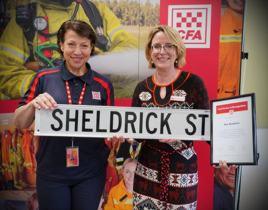 Big moment: Sue Sheldrick with CFA chief executive Natalie MacDonald and a copy of the street sign which greets Victorian trainee firefighters. She also received a certificate of recognition.