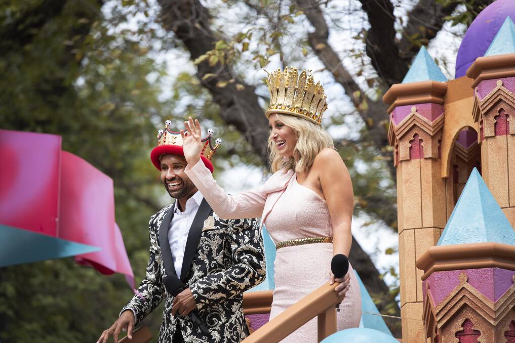 On a high: Moomba Monarchs Archie Thompson and Jane Bunn soak up the atmosphere as they travel through Melbourne on their Moomba float. Thompson's paisley Jack London jacket was provided by a stylist friend from Sydney. 