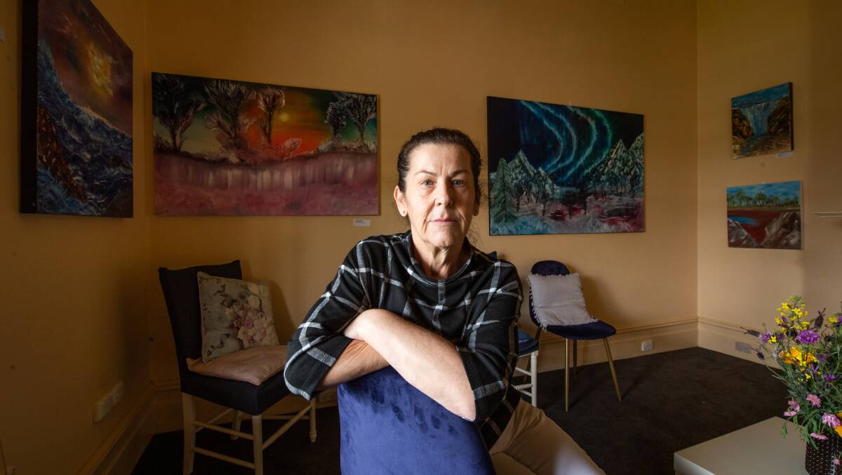 On show: Liz Marmo in the Albury waiting room surrounded by some of the 17 paintings she completed during a flurry in March-April. Picture: MARK JESSER