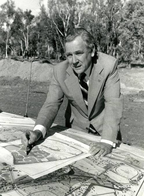 Drawing bonnet: Les Muir places his hands on his car and plans for the Corrys Wood housing estate at Thurgoona in an undated Border Mail photograph. 