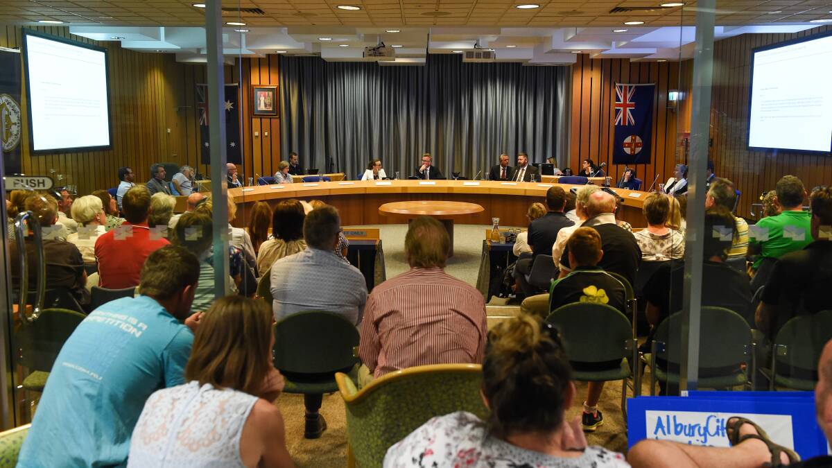 Not impressed: A council meeting last October which was packed out with pool users, including some left unimpressed by councillors on their phones during the forum. Picture: MARK JESSER