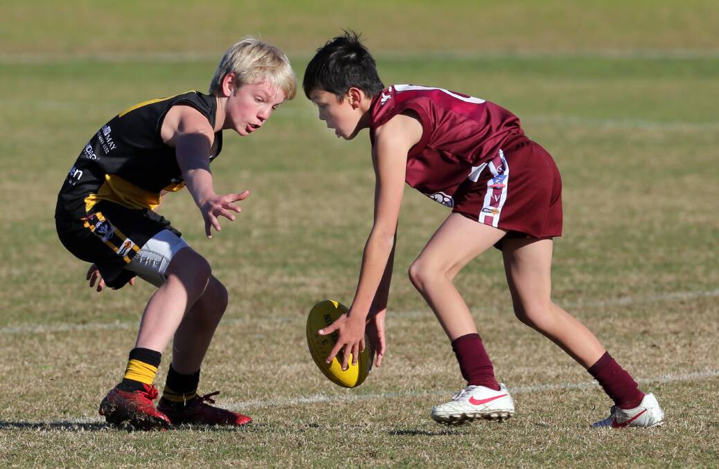 Flashback: Elijah Hollands during his under-12 days playing for Wodonga against Albury as he looks to sidestep Sam Cavanough. 