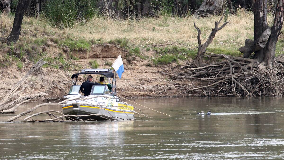 On the job: A Volunteer Rescue Association boat with a diver on a line searching the Murray River in 2013.