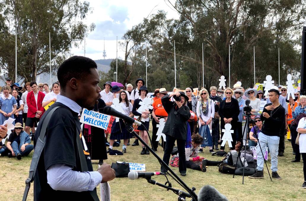 Airing his poetry: Christian Bashimbe reads his verse to those gathered at the rally outside Parliament House. Picture: JAMIE KRONBORG
