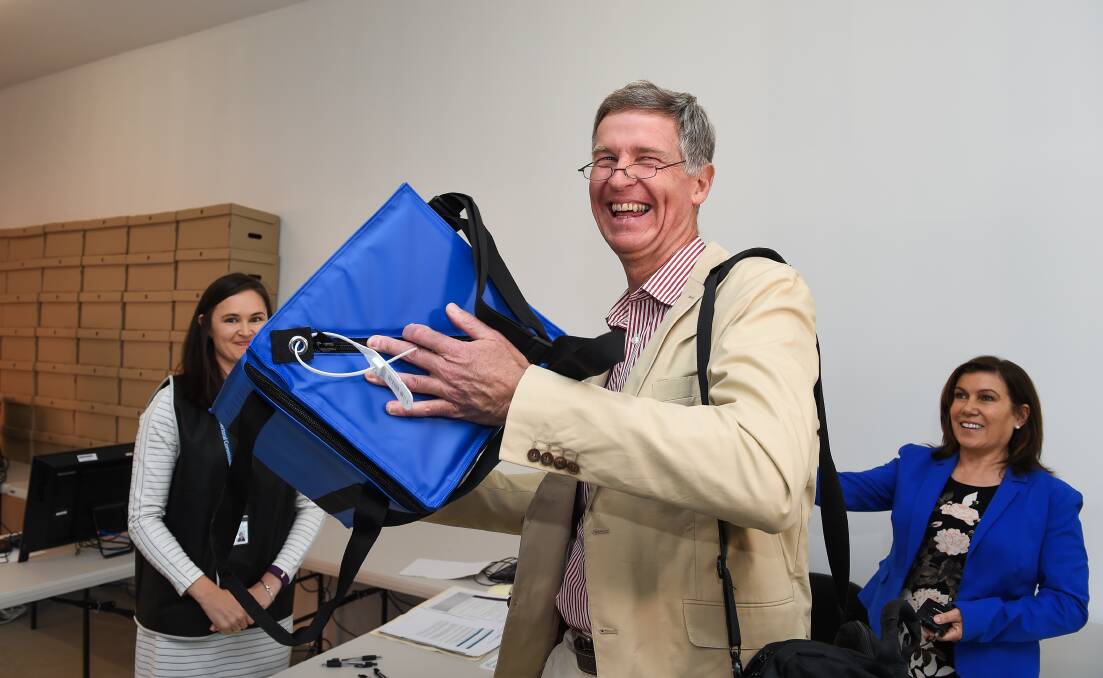 Giving it a shake: Lauriston Muirhead gives the box used for the ballot draw a tilt to ensure the names are mixed up. Picture: MARK JESSER