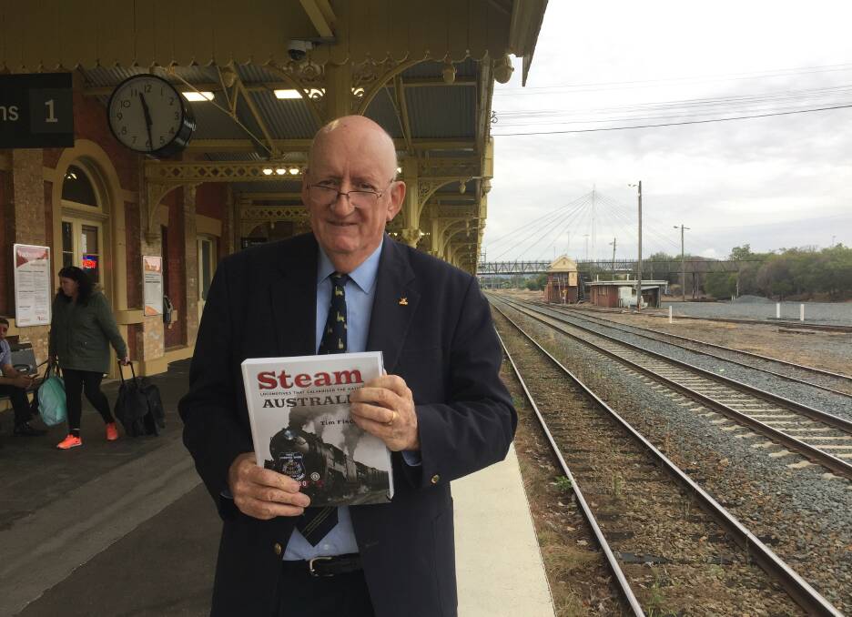 Full of hot air: Tim Fischer on the Albury railway station platform on Wednesday with his sixth book which examines great steam locomotives in Australian history. It features images from the National Library of Australia. 