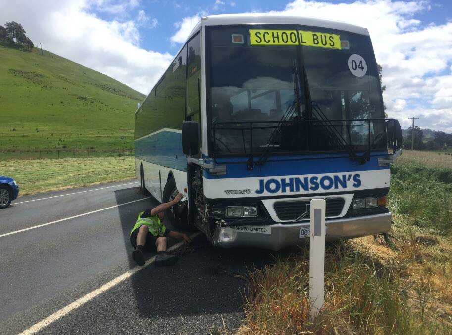 Retrieval operation: Tow truck driver Chris Bourke studies the undercarriage of the bus as he prepares to remove it from the side of the Beechworth-Wodonga Road.