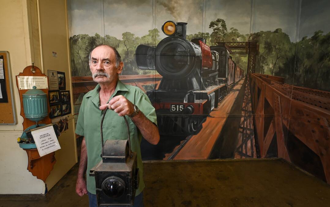Bernie Williams at Tocumwal's station in April with a mural of the town's Murray River railway bridge in the background. The span has now got water lapping at it as flooding heads downstream. Picture by Mark Jesser