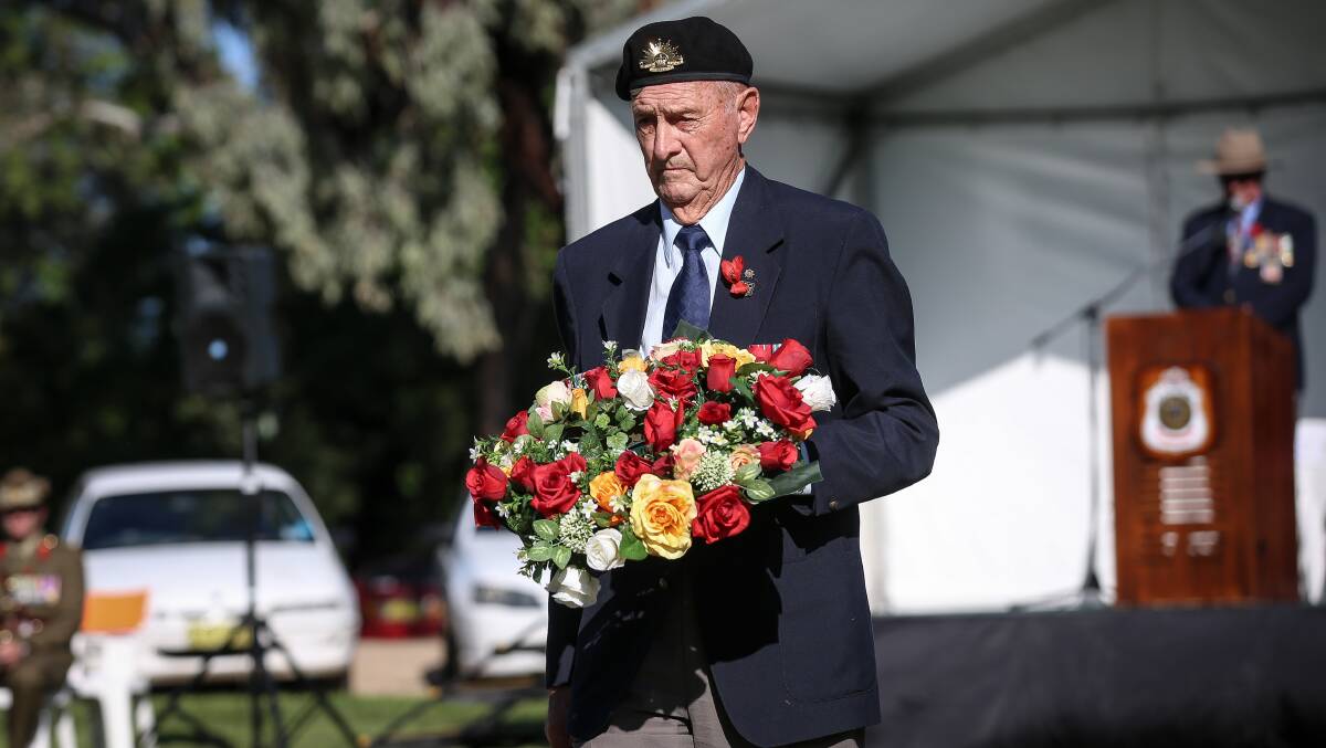In thought: Rowan Chalmers-Borella deposits a wreath at a makeshift flag pole to recognise his father, Victoria Cross recipient Albert Borella, who is buried in the newer section of the Waugh Road cemetery. Picture: JAMES WILTSHIRE