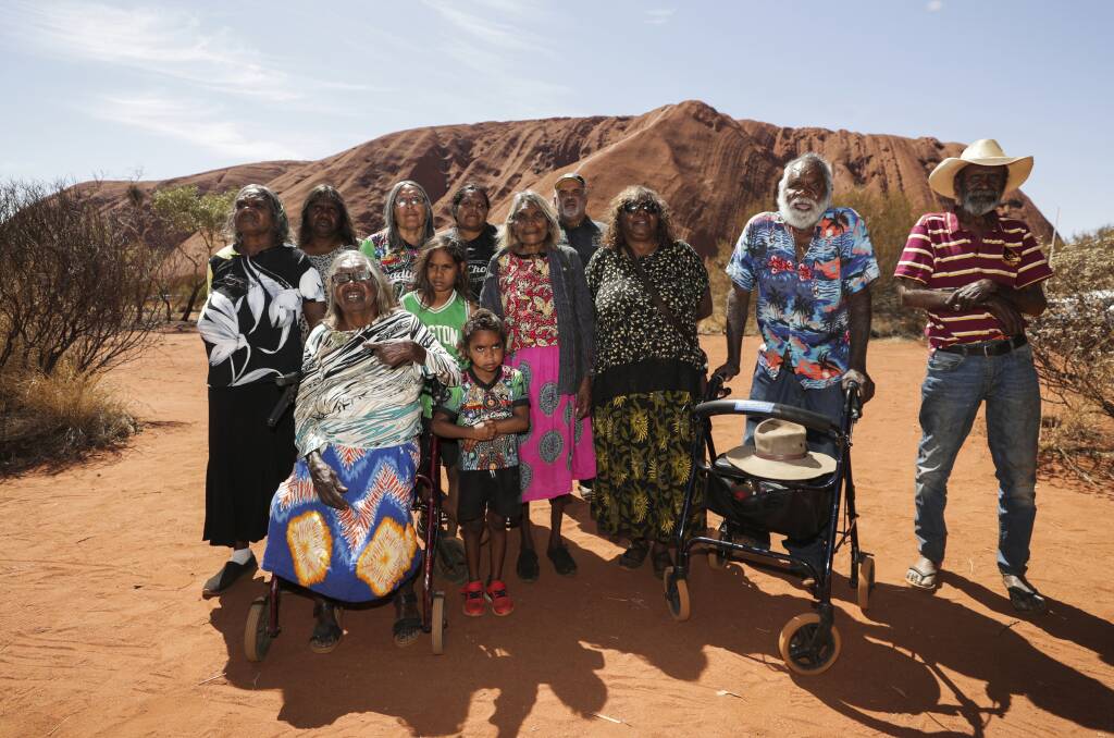 Relieved: Traditional owners of Uluru gather at the rock following the ban on climbing taking effect last Friday.