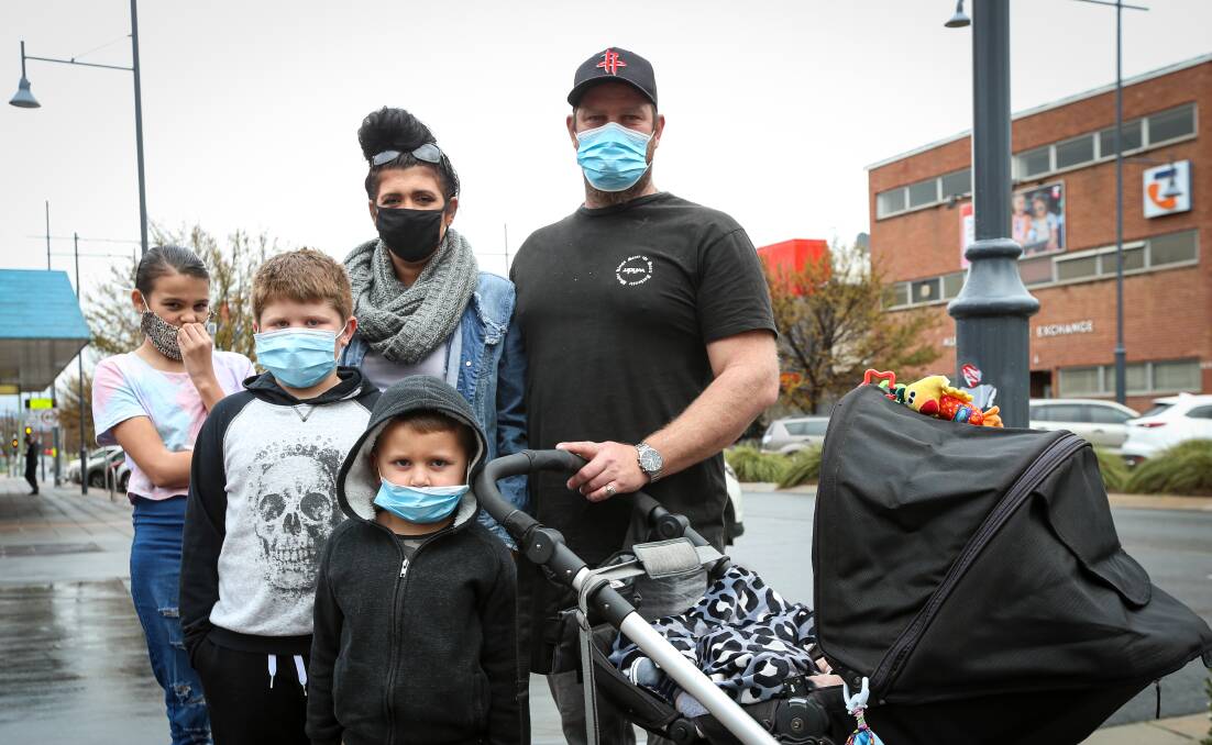 All covered: Sianne Mather and Ryan Kolm and children Kiesha, 10, Lennox, 8, Djabarri, 5, were all wearing masks as they were out with baby Lyrik, eight months, on Sunday. Picture: JAMES WILTSHIRE
