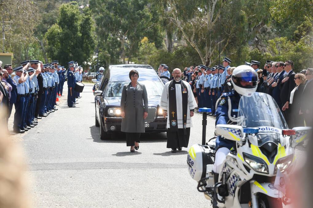 Goodbye: Police officers salute and place hands on their hearts as they form a guard of honour to salute Detective Senior Constable Saunders following her funeral at Albury's Hovell Tree Park. Picture: MARK JESSER