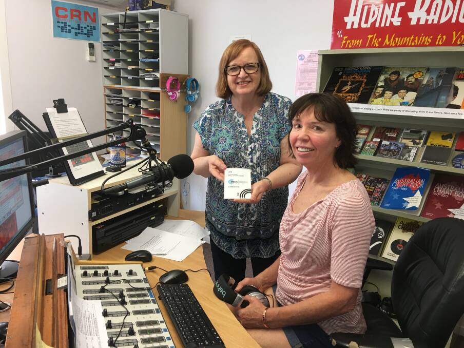 Success story: Vivienne Rochford holds the winning trophy as presenter Christine Riches rests her headphones at the panel in the Mount Beauty studio of Alpine Radio.