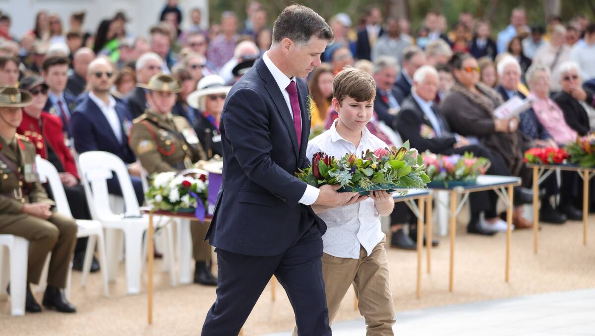 Family affair: Albury MP Justin Clancy was assisted by his son Xavier, 12, in depositing a wreath at the base of the monument. Picture: JAMES WILTSHIRE