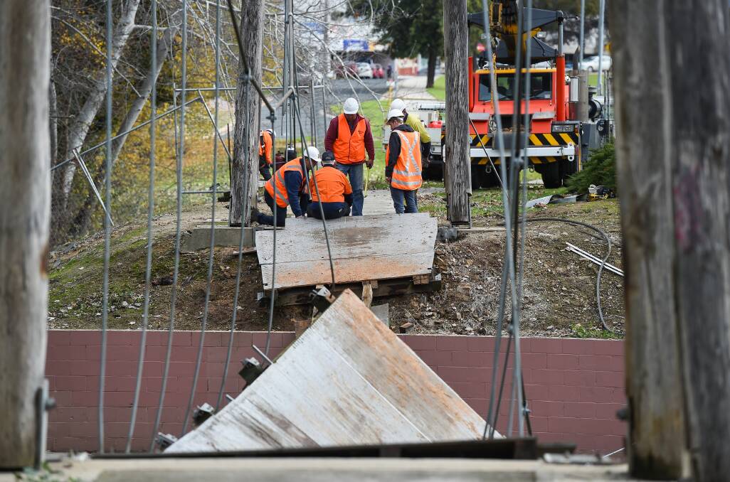 Coming down: Workers remove the decking on the suspension bridge which is being replaced because of safety concerns. The new prefabricated span is expected to be installed next week. Pictures: MARK JESSER
